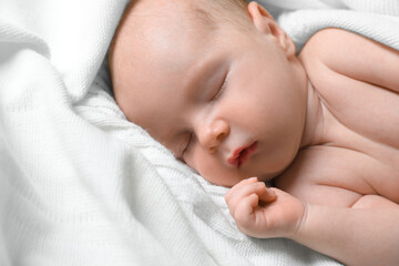 Cute newborn baby sleeping on white blanket, closeup