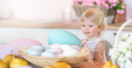 A small kid holds a large colored Easter egg in his hands. Easter card with copy space
