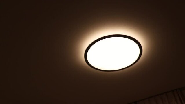 暗い部屋で光る円形のシーリングライト
