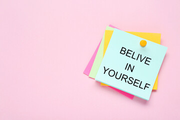 Notes with phrase Believe In Yourself and space for text on pale pink background, top view. Motivational quote