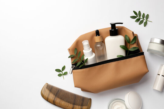 Preparation For Spa. Compact Toiletry Bag With Cosmetic Products, Comb And Twigs On White Background, Top View. Space For Text