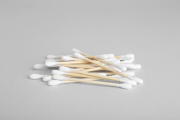 Wooden cotton buds on light grey background