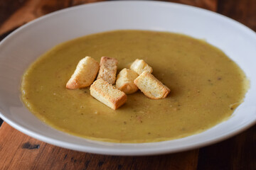 Closeup split pea soup in white bowl with croutons