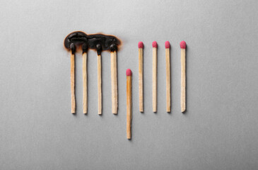 Burnt and whole matches on light grey background, flat lay. Stop destruction by breaking chain reaction concept