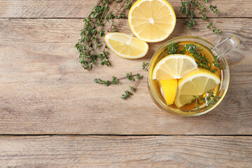 Aromatic herbal tea with thyme and lemon on wooden table, flat lay. Space for text - obrazy, fototapety, plakaty
