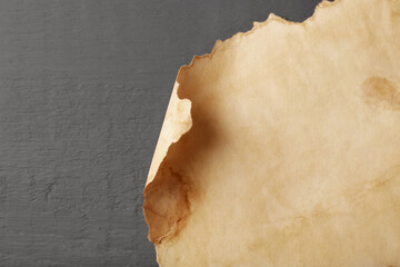 Sheet of old parchment paper on grey wooden table, top view. Space for text
