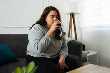 Lonely big woman drinking wine alone