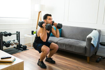 Sporty man using weights during his home workout