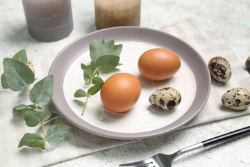 Table setting with Easter eggs and plant branch on white grunge background