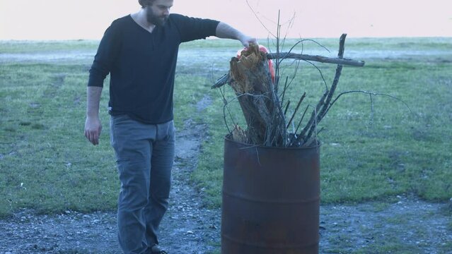 Young Man Tending Trash Can Fire in Rural Tennessee USA BMPC4K