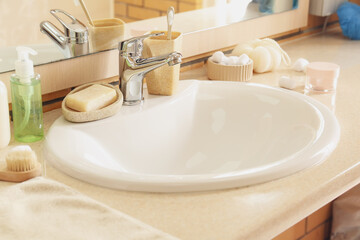 Table with white ceramic sink and bath supplies in room