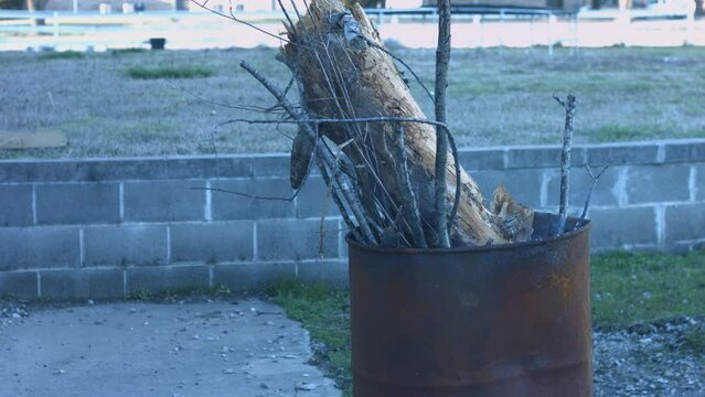 Young Man Tending Trash Can Fire in Rural Tennessee USA BMPC4K
