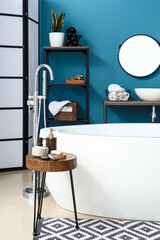 Interior of bathroom with sink, bathtub and shelving unit