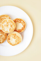 Plate with delicious cottage cheese pancakes on color background, closeup
