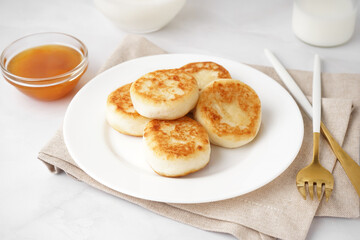 Obraz na płótnie Canvas Plate of tasty cottage cheese pancakes with jam on light background