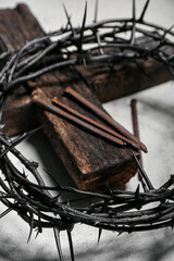 Fototapeta na wymiar Crown of thorns, wooden cross and nails on grunge background, closeup