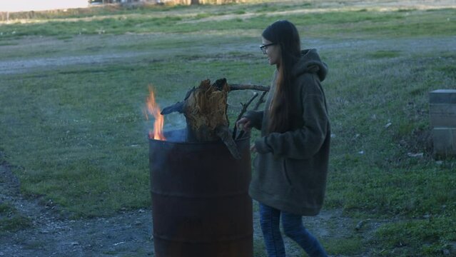 Young Woman Tends To Trashcan Fire In Rural America Countryside BMPC4K