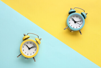 Alarm clocks on blue and yellow background