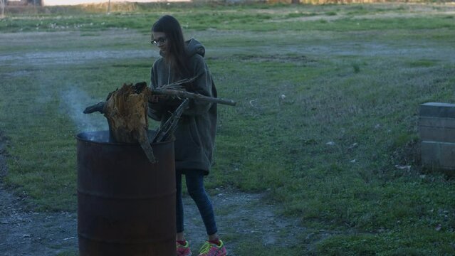 Young Woman Tends To Trashcan Fire In Rural America Countryside BMPC4K
