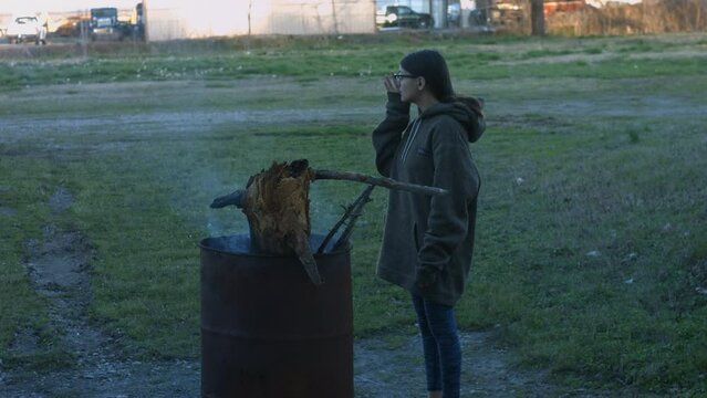 Young Woman Tends To Trashcan Fire In Rural America Countryside BMPC4K