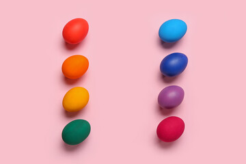 Frame made of colorful Easter eggs on pink background