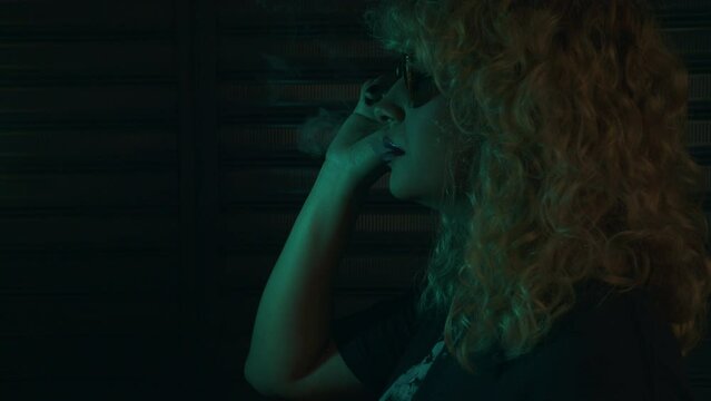 profile view of a Latina woman with sunglasses smoking vapear 