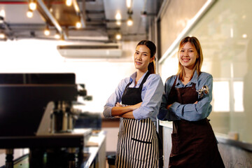 Portrait of happy multiethnic women working in a coffee shop. Successful small business owner in casual brown apron making coffee. Cafe owner and small business concept