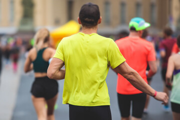 Fototapeta premium Marathon runners crowd, participants start running the half-marathon in the city streets, crowd of joggers in motion, group athletes outdoor training competition in the rain