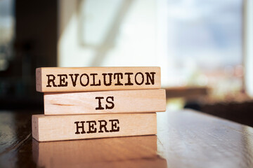 Wooden blocks with words 'Revolution is Here'.
