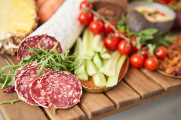 Salami sausage close-up. Table full of mediterranean appetizers, tapas or antipasto. Assorted Italian food set. Delicious snack on party or picnic time. Meat and cheese. Italian style banquet. 