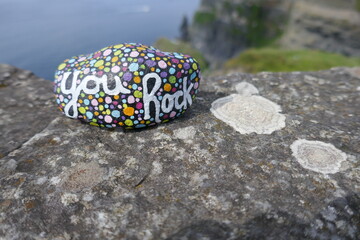 Kindness stone with hand painted you rock message on stone with lichens growing	
