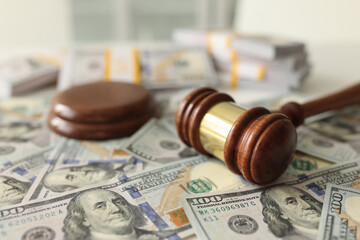 Judge gavel on dollar banknotes background, shallow depth of field.
