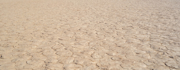 Dry ground rough cracks in the land with sand in paddy rice field. serious water shortages and Drought barren arid pattern texture background.