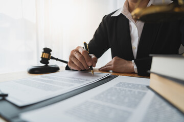 Lawyer, legal adviser, asian businesswoman looking at and writing down contract details business law Study and check the accuracy before signing and clarifying in the office.