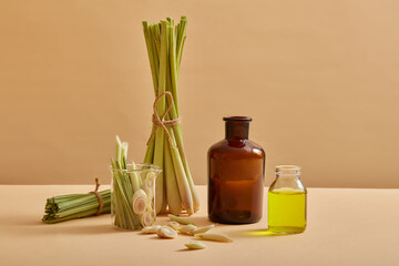 Few bunches of lemongrass and glass bottles containing lemongrass essential oil are decorated. Lemongrass (Cymbopogon citratus) is appropriate for skincare, haircare and healthcare