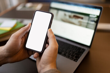 Closeup of man hand holding smartphone using mobile app shopping online,  looking at blank display. Mockup. Modern male ordering food, selective focus
