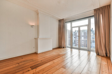 an empty living room with wood flooring and sliding glass doors leading to the balcony area in the...