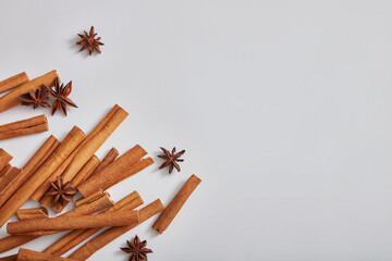 Blank minimal design concept with cinnamon sticks and anise on white background. Frame for advertising product of natural extract. Space for text and design. Top view, flat lay.