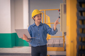 Asian woman Engineer using computer working in factory