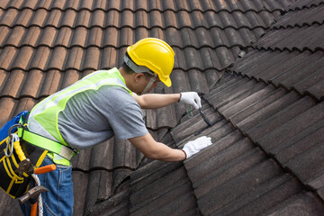 Worker man using waterproof roof coating repair to fix crack of the old tile roof. - obrazy, fototapety, plakaty