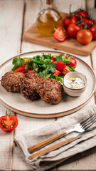Portion of russian beef cutlets with sauce and salad