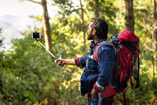 traveler man taking selfie portrait on the top of mountain for conecte friend