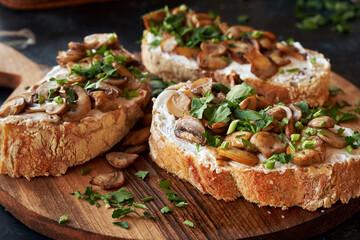 Close-up of appetizing bruschetta cream cheese and fried champignon mushrooms.