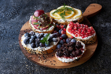 Top view of many appetizing bruschettas with cream cheeses. On a beautiful dark background.