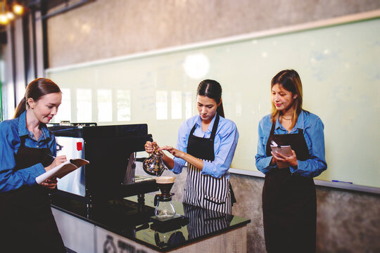 An experienced female barista in uniform will demonstrate how coffee is made and provide a master class. Small business and cafe owner concept