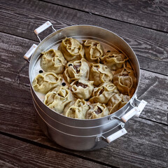 Ready-made hot manti in an aluminum cooker.