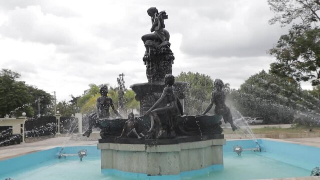 Vista de fuente con estatuas ornamentadas en parque en republica dominicana.
