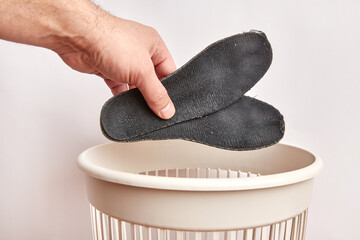 Old shoe insoles are thrown into the trash. Waste disposal and recycling.