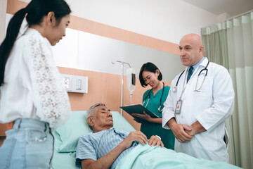 Obraz premium professional doctor standing by explain the treatment information via male elderly patient lying in bed in private hospital sickroom. The treatment program is suitable for people to socialize elderly