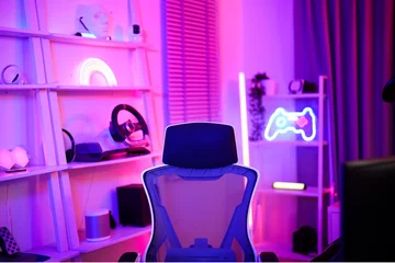 Fotobehang Gaming Gamer ergonomic chair with remote controller car, wireless VR and entertainment gadget in neon light room  © MergeIdea